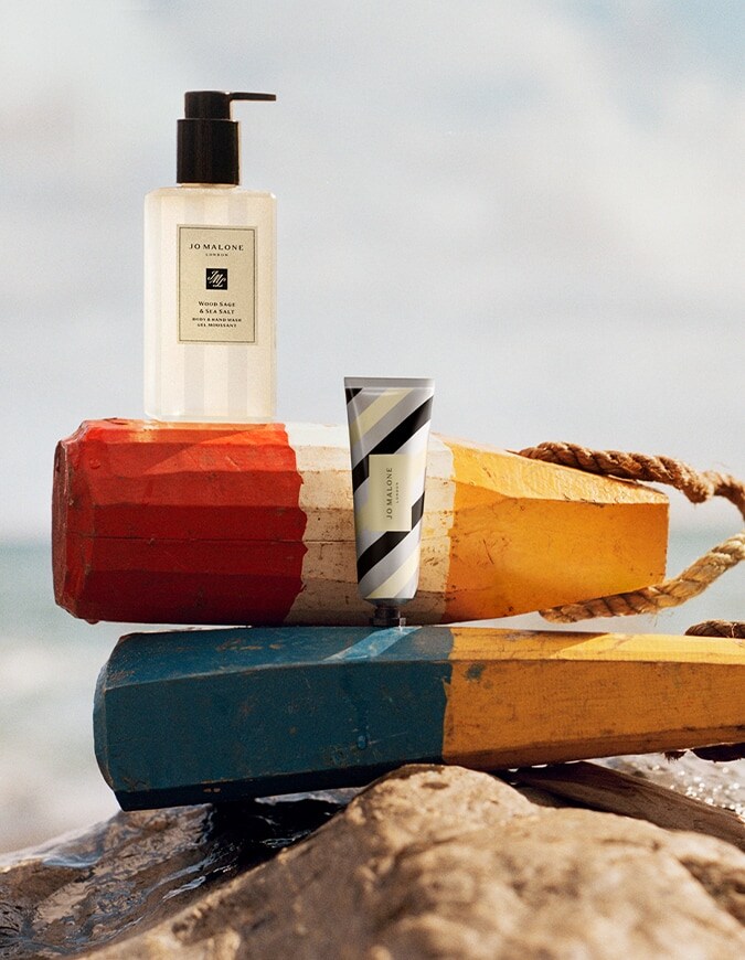 Jo Malone London Wood Sage & Sea Salt body & hand wash with silver striped hand cream on seaside buoys.