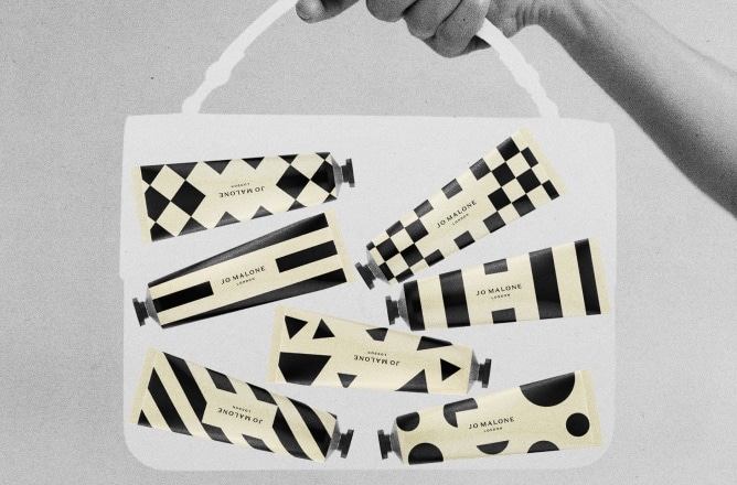 Black, white & cream image of a transparent, medium bag held by a hand, containing seven patterned hand creams in tubes.