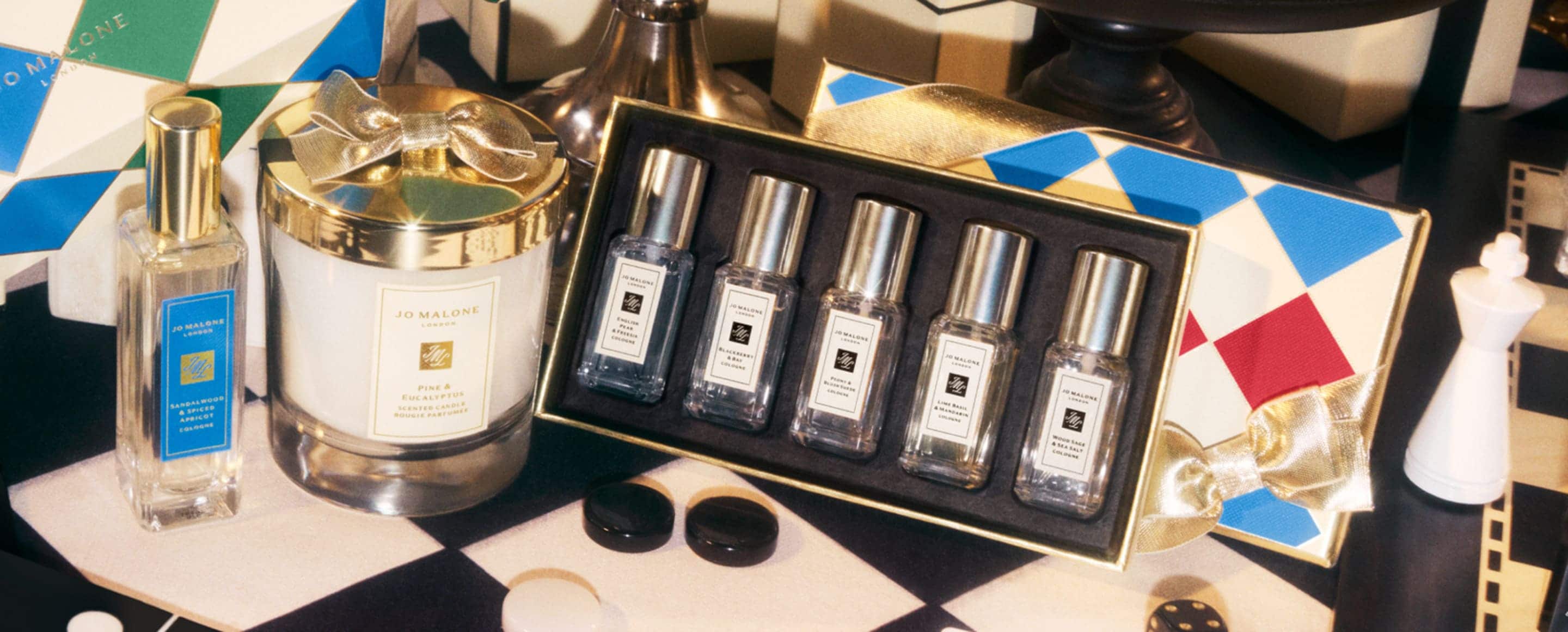 Jo Malone London fragrance Gift Sets and crackers next to mini tinsel tree and pink bauble